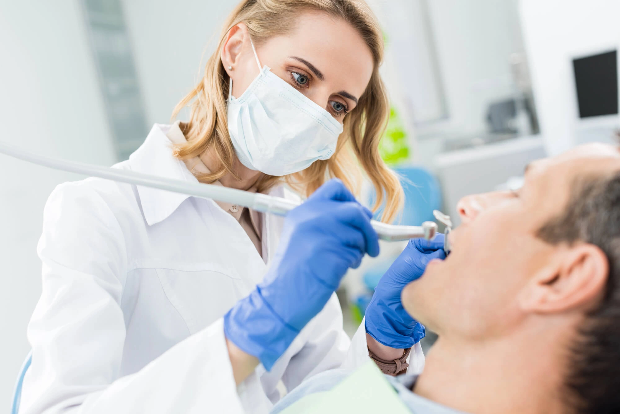 Man-undergoing-tooth-extraction-by-a-dentist-greenfield