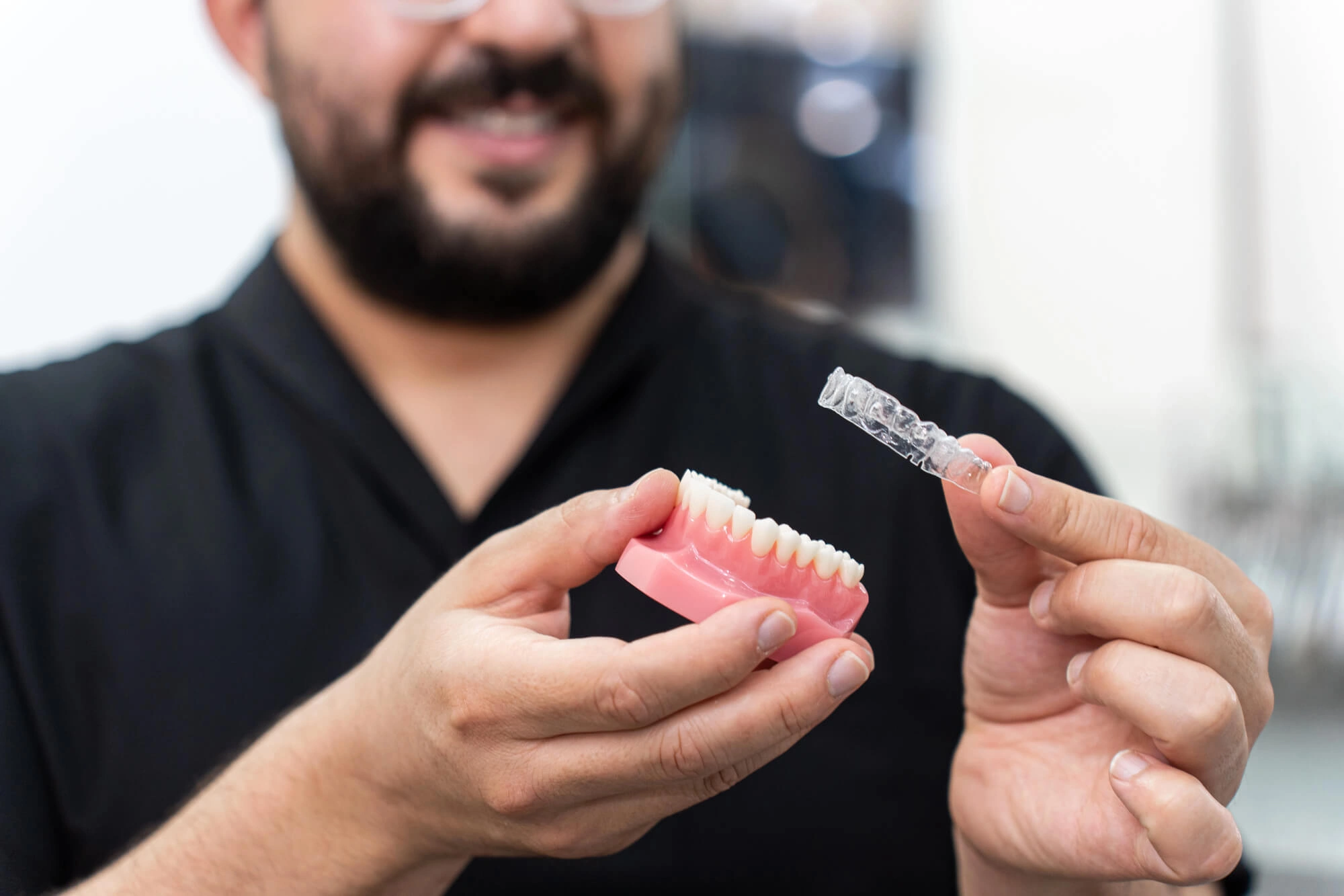 Dentist-holding-Clear-aligners-Clawson-MI